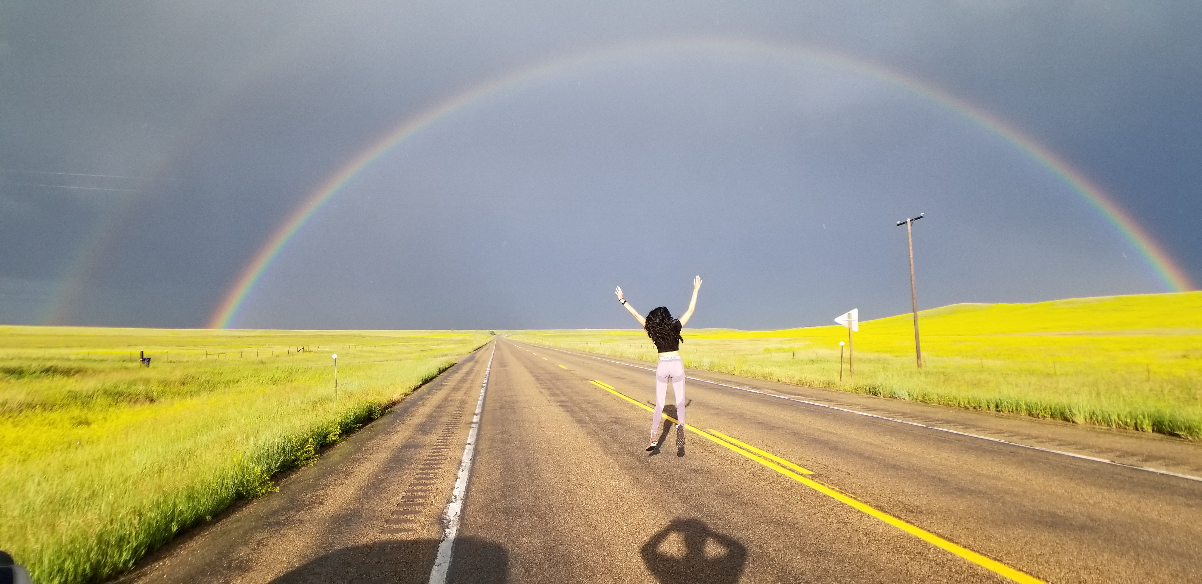 Zelzah frolics under a rainbow after an intense thunderstorm in western Montana