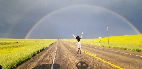 Zelzah frolics under a rainbow after an intense thunderstorm in western Montana